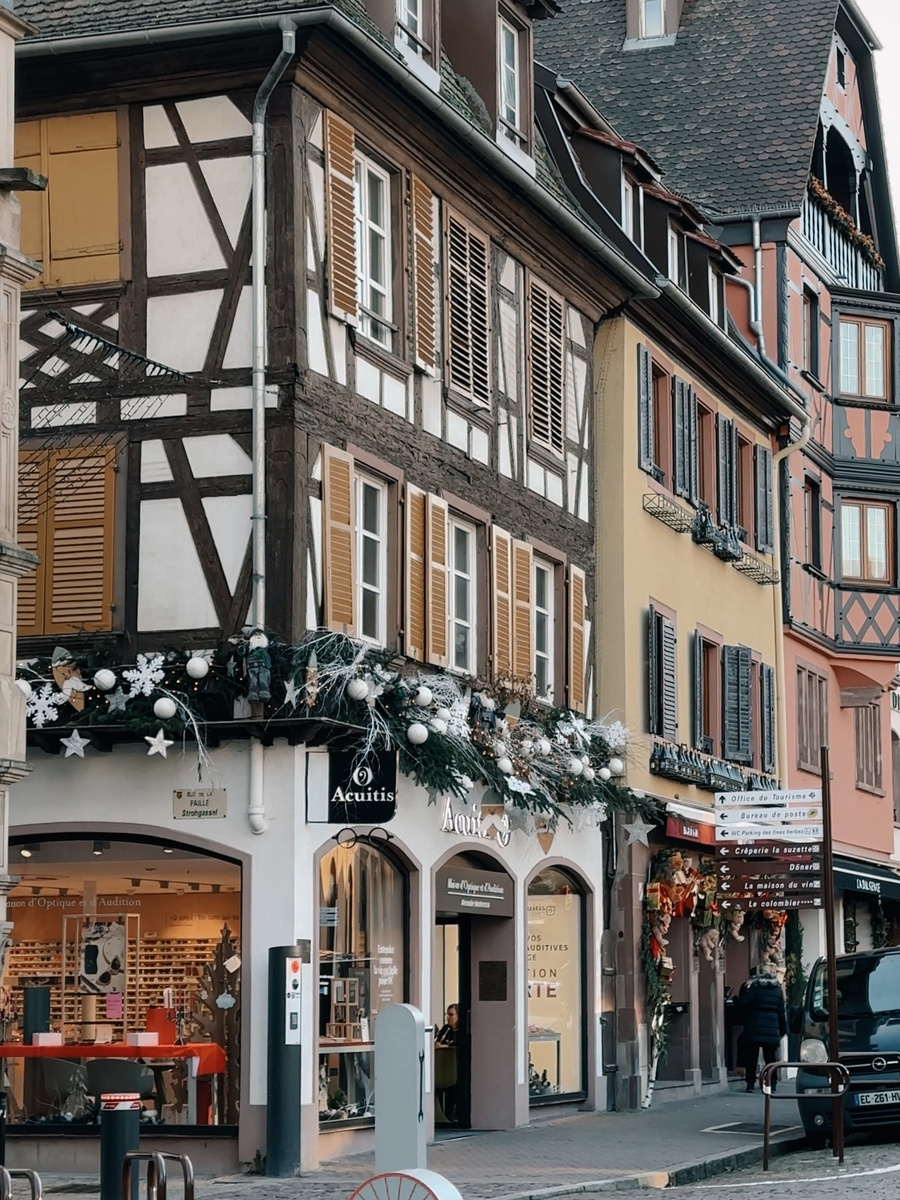 Half-timbered shops and Christmas garlands at the corner of Rue de la Paix in Obernai.