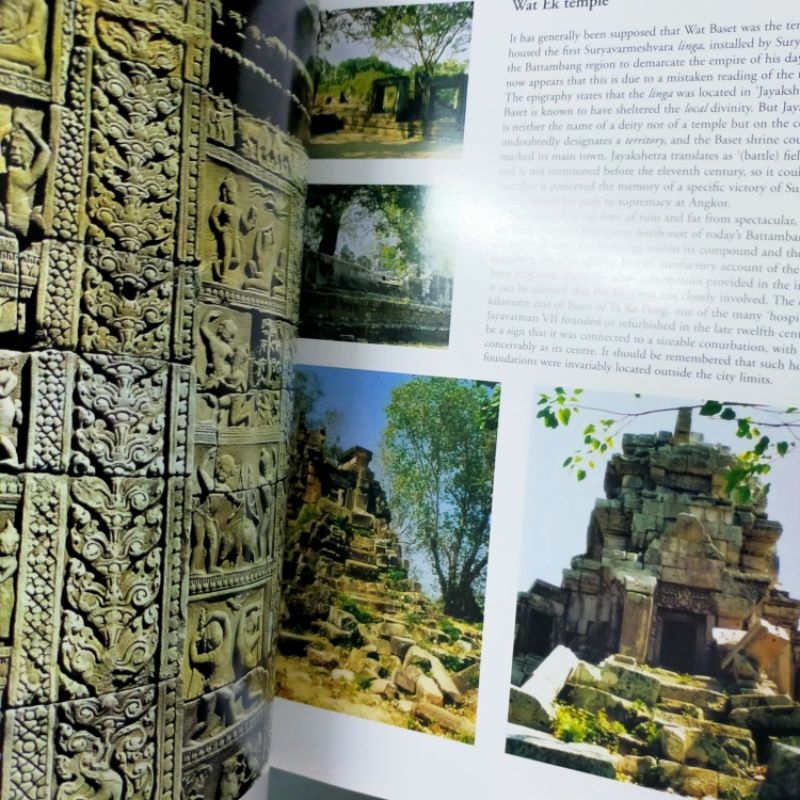 Open pages from The Khmer Empire, showing carved stonework and photographs of Khmer temple ruins.
