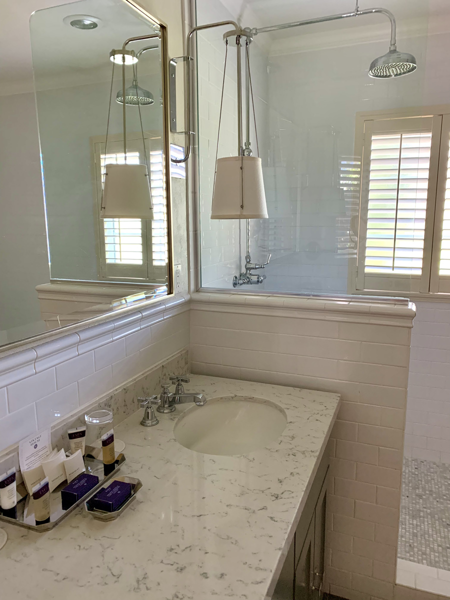 Marble vanity, white tiles and a glass-screened shower in our Vintage House bathroom.