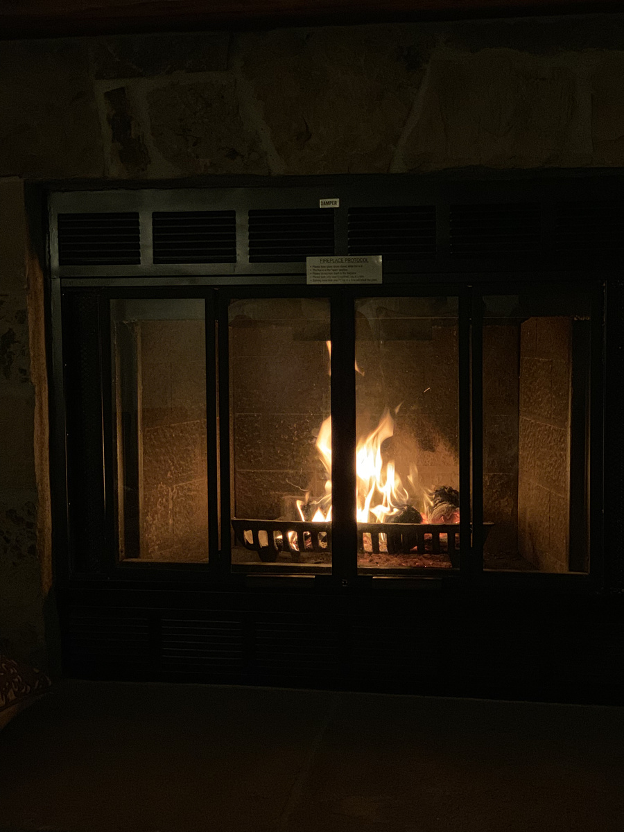 A fire burning behind the glass doors of our room’s stone fireplace at Vintage House.