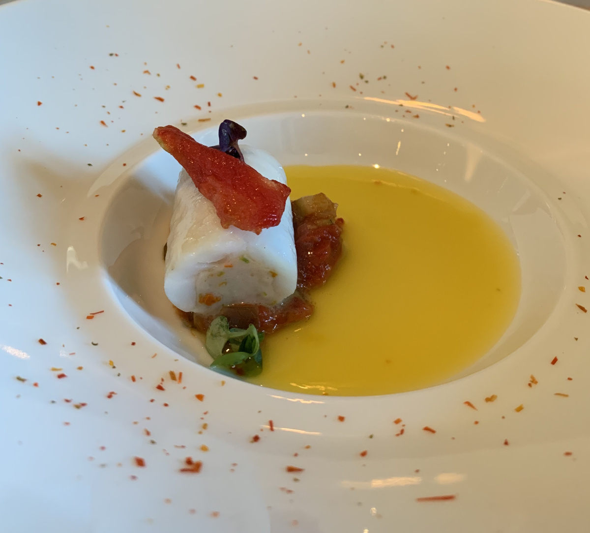 A plated course with a pale centre, crisp garnish and yellow sauce at The French Laundry.