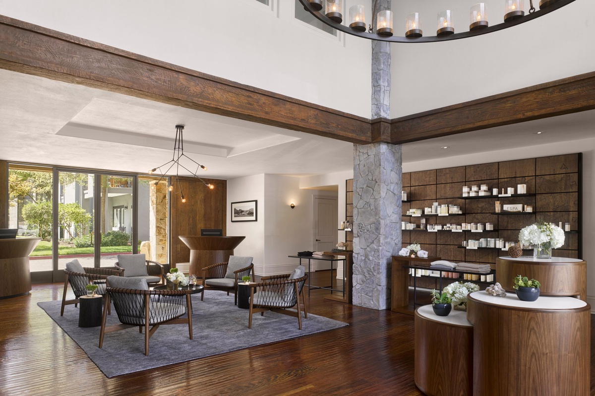 The Estate spa reception with a stone column, timber beams, woven chairs and an ESPA product display.
