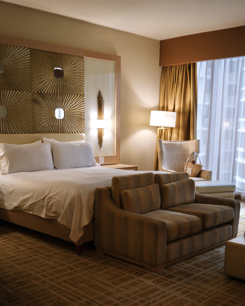King bed and sofa beside the window in a room at Waldorf Astoria Panama.