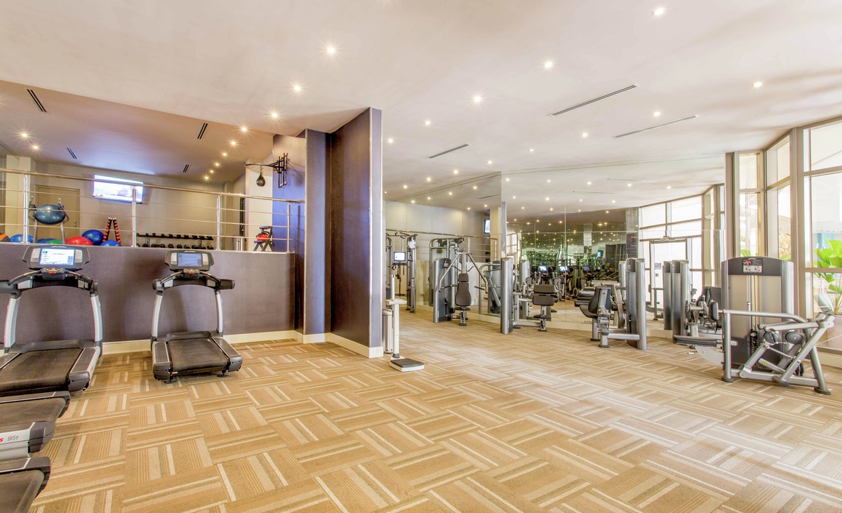 Cardio and resistance machines in the spacious fitness centre, with tall windows and a raised free-weight area at Waldorf Astoria Panama.